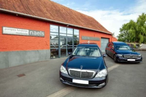 Flotte de corbillards Mercedes garés devant l'agence Pompes Funèbres Naels.