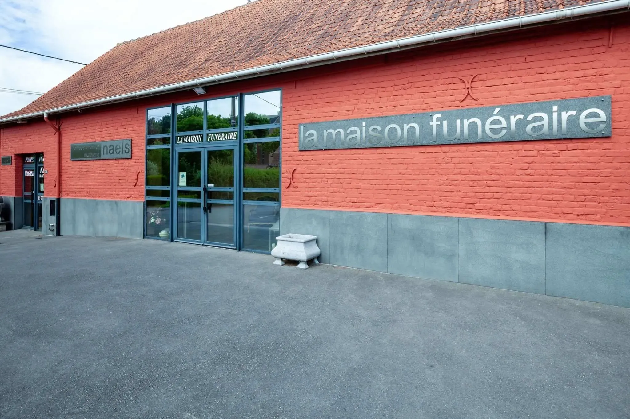 Façade extérieure de la maison funéraire Naels en briques rouges.