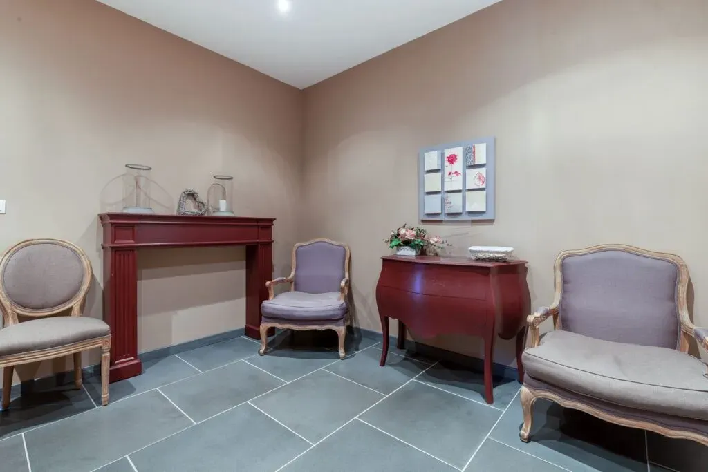 Salon de recueillement et d'accueil aux tons chaleureux dans la maison funéraire.