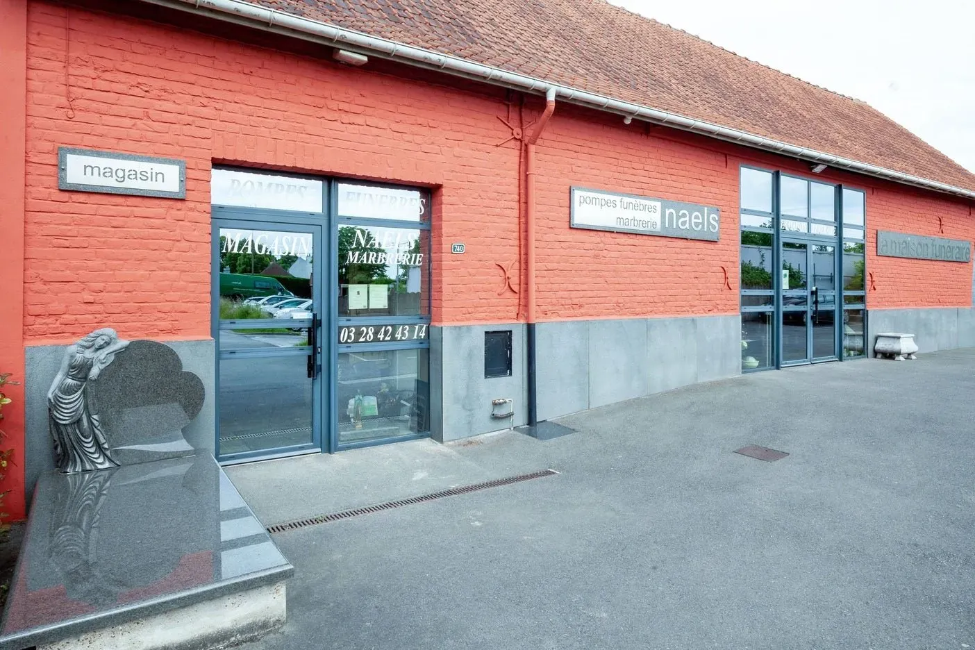 Devanture du magasin et de la maison funéraire Naels en briques rouges.