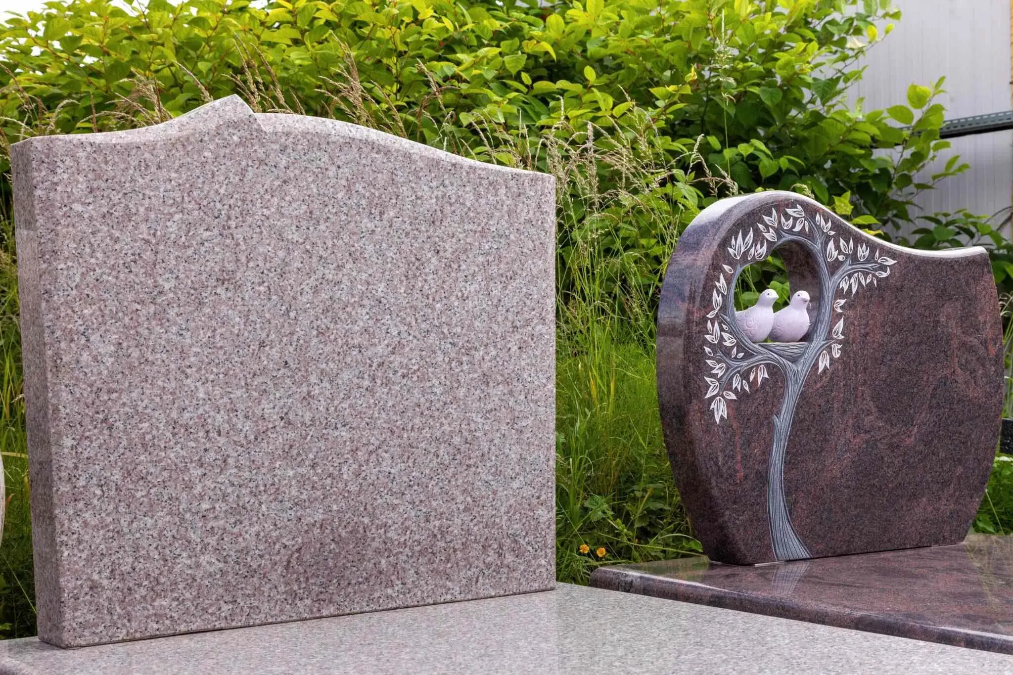 Stèles funéraires en granit sculpté représentant un motif d'arbre et d'oiseaux.