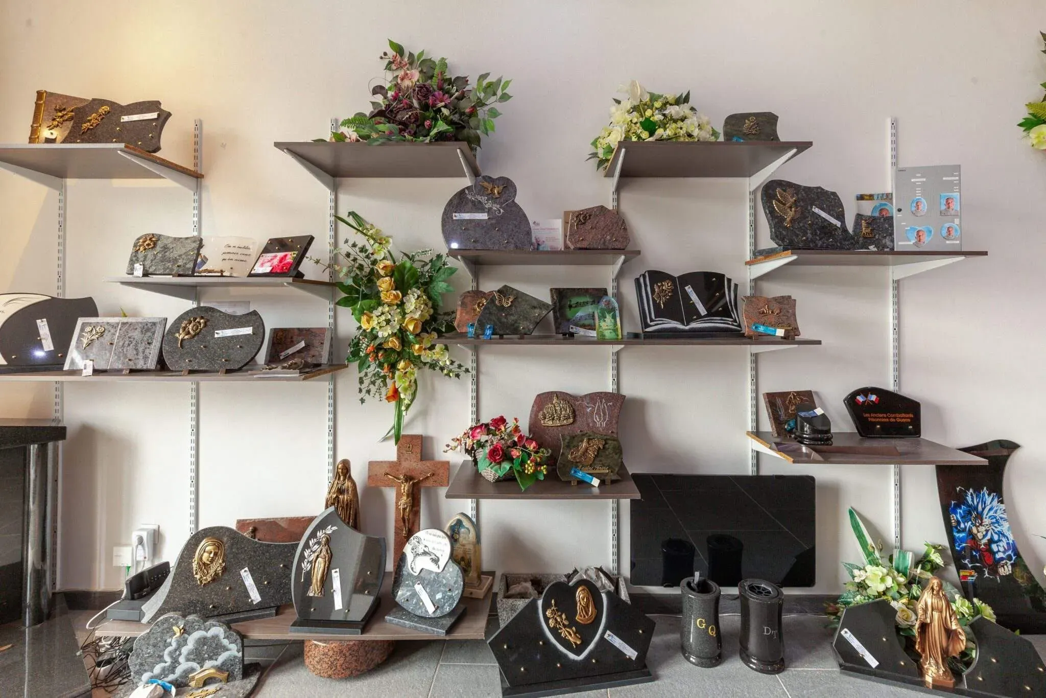 Rayonnage de magasin exposant des plaques funéraires en granit et des ornements du souvenir.