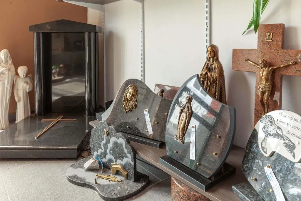 Plaques funéraires en granit personnalisées et objets religieux exposés en magasin.